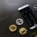 A smartphone displaying a crypto wallet app with Bitcoin symbols, highlighting tips for creators.