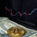 Bitcoin coins stacked with a fluctuating stock market chart in the background.