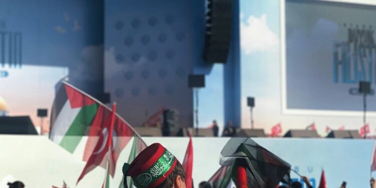 Diverse audience at a summit filled with banners for crypto and AI political speakers.