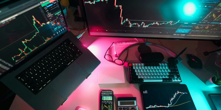 Two business people analyzing cryptocurrency transactions on a digital tablet amidst financial charts.