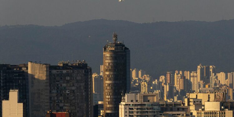 Aerial view of São Paulo with skyscrapers, symbolizing urban real estate and financial regulation.