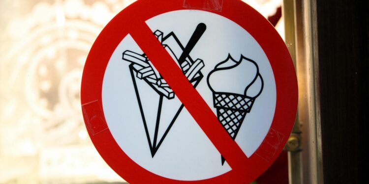 Crypto coins with a warning sign representing USDC freezing policy amid theft controversy.