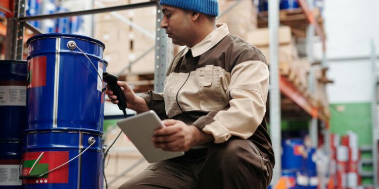 Men working on cryptocurrency mining equipment in a tech warehouse setting.