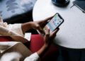 A cozy café setting with people interacting with AI companions on digital devices.