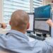 Traders at computer screens display the NYSE logo and charts of tokenized stock transactions.