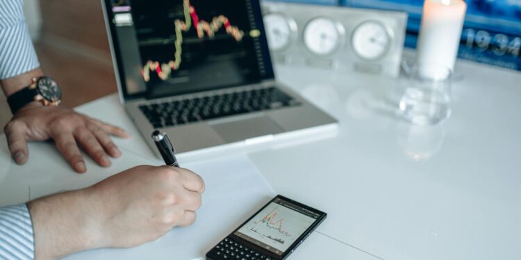 A person examining Bitcoin charts on a laptop, highlighting cryptocurrency risks.
