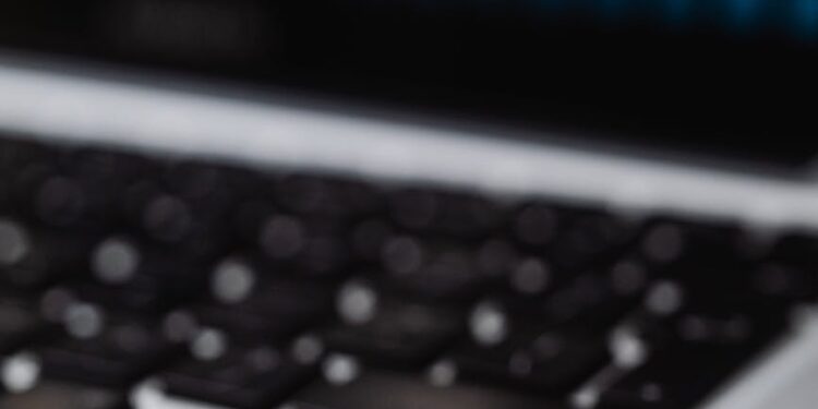 Stacks of cash beside a laptop displaying cryptocurrency charts and a legal document.