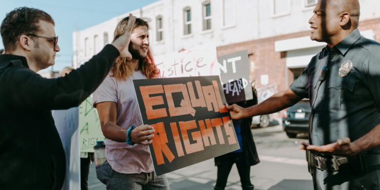 Protestors holding signs march through the streets, internet blackout affecting communication.