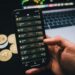 Tether logo superimposed on a background of Bitcoin coins and financial graphs.