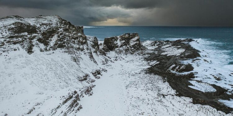 Snow-covered Bitcoin mining rigs in a harsh winter landscape affected by an Arctic storm.
