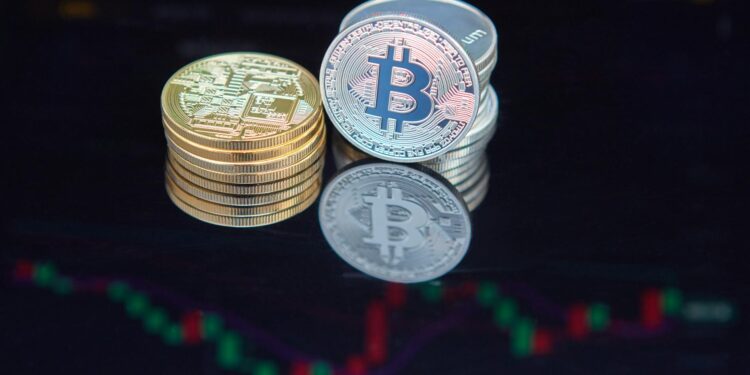Bitcoin coins stacked on a table with financial charts in the background, symbolizing investment growth.