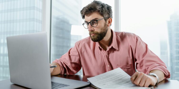 Bitcoin ATM with a digital currency screen, surrounded by financial documents and money.