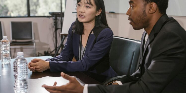 Two professionals discussing Bitcoin management strategies in a modern office setting.