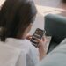 A person using a smartphone, highlighting concerns over messaging app security risks.