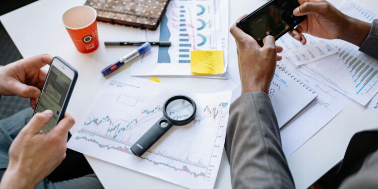 People using smartphones in Uganda, discussing the Bitchat app amidst election preparations.