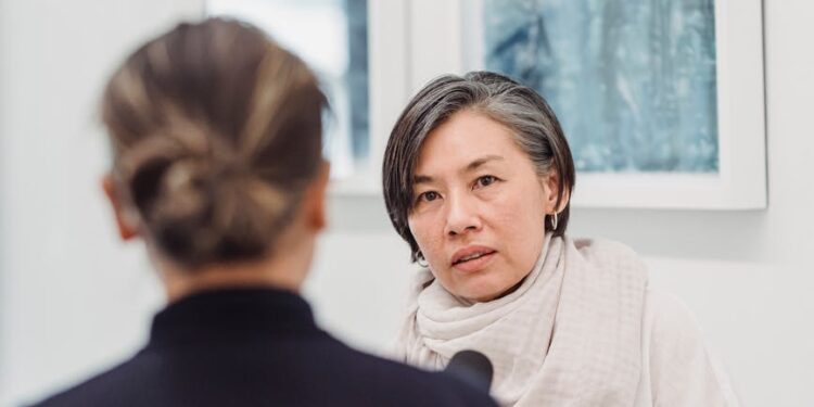 Eric Adams speaking at a press conference with NYC skyline in the background, discussing crypto.