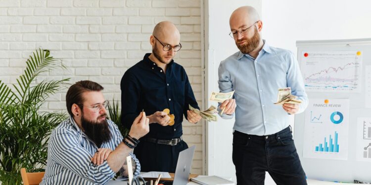 A team of professionals discusses finance in a dimly lit startup office, reflecting challenges.
