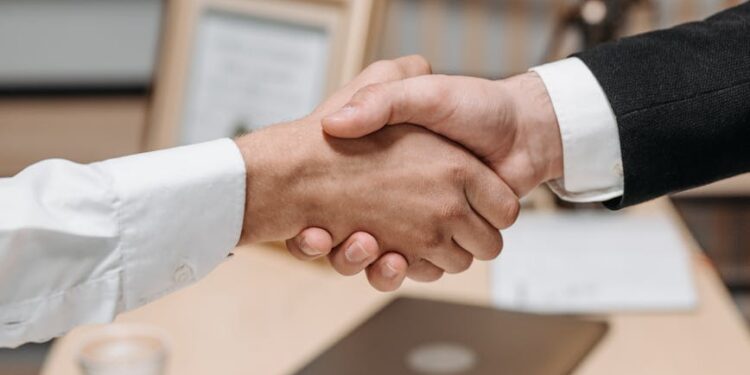 Wikimedia representatives shaking hands with AI executives at a partnership announcement event.