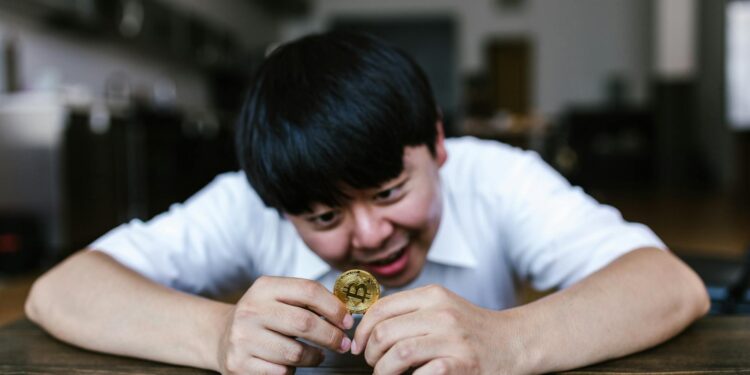 Kain Warwick looking at financial charts with a worried expression in a crypto trading environment.