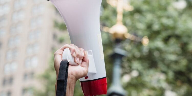 María Corina Machado speaking at a political rally, surrounded by supporters in Venezuela.