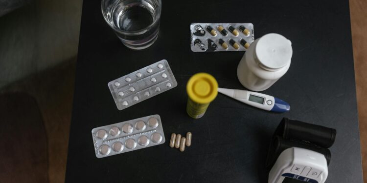 A bottle of Wegovy pills sits on a table with a weight scale in the background.