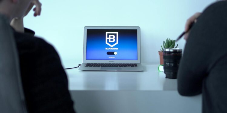 A person using a laptop in a hotel lobby with a visible WiFi connection prompt and crypto wallet app.