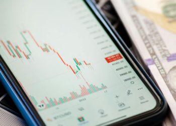 A chart showing a decline in oil prices alongside a news headline about tariffs.