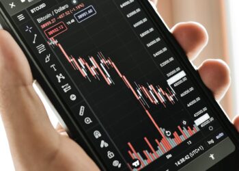 Financial graph showing Bitcoin price decline alongside a stock chart with significant losses.