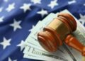 A gavel rests on a legal document alongside cryptocurrency symbols and a US flag.