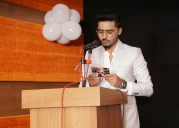 Trump speaking at a podium with federal agencies' logos in the background, addressing AI regulation.