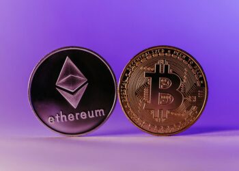 A digital display showcasing the Kraken logo with stock market graphs and crypto tokens.