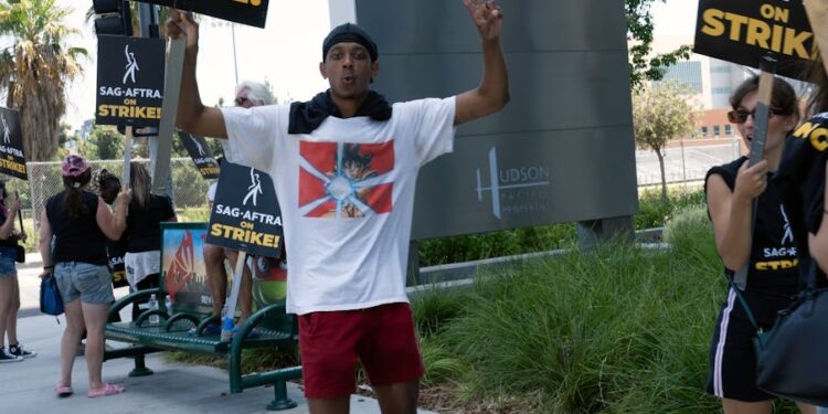 Workers protesting outside a bank, holding signs advocating for fair wages and digital payment access.