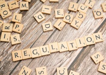 Cryptocurrency symbols overlaid on UK regulatory documents and gaming platforms.