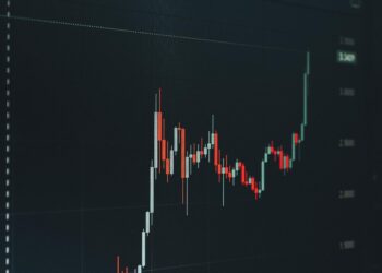 XRP cryptocurrency coin surrounded by downward trending financial charts.