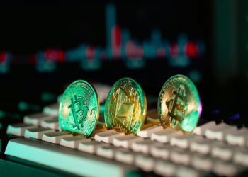 Enoch Godongwana speaking at a podium with financial charts and cryptocurrency symbols in the background.