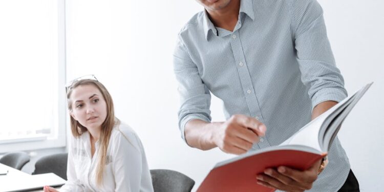 Employees in a corporate office reviewing documents amid discussions on workforce strategy changes.