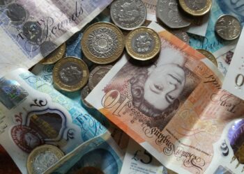 Graph showing rising crypto ETN values with a calculator and British pound notes in the background.