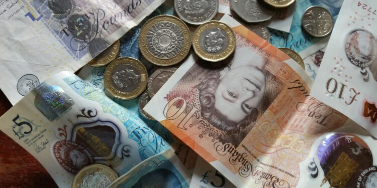 A digital coin symbolizing a British Pound stablecoin with financial charts in the background.