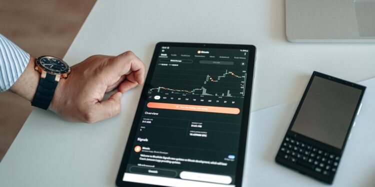 A trader anxiously watches Bitcoin charts on multiple screens amid market turmoil.