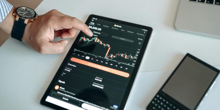 HSBC logo on a digital screen with blockchain graphics and financial charts in the background.