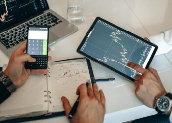 A trader analyzes market data on a laptop with cryptocurrency charts and graphs displayed.