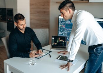 Modern office scene with professionals discussing cryptocurrency finance strategies.