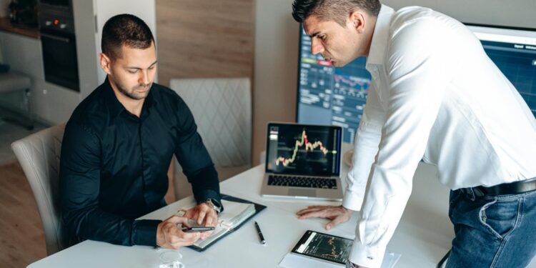 Business executives discussing cryptocurrency investment at a conference table.