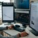 A trader analyzing financial charts on multiple screens with AI algorithms displayed.