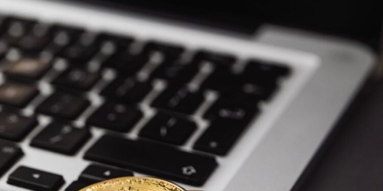 A fintech professional reviewing digital crypto card designs on a laptop.