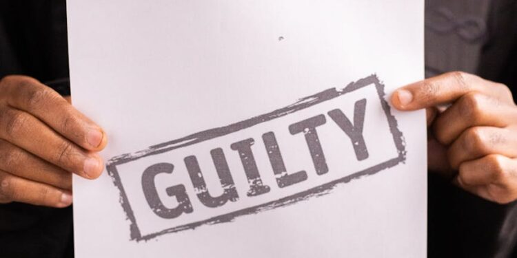 Judge delivering a sentence in a courtroom with Bitcoin logos displayed on a screen.