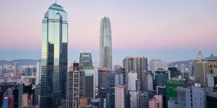 A skyline of Hong Kong with digital currency symbols and financial icons superimposed.