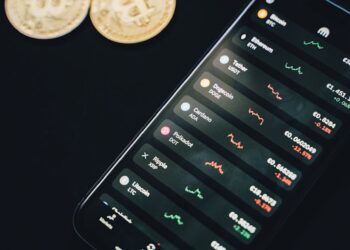 Two tech executives discussing cryptocurrency development, with digital charts and coins visible.