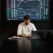 A trader analyzes Bitcoin prices on a digital exchange amidst news of DeFi liquidity issues.