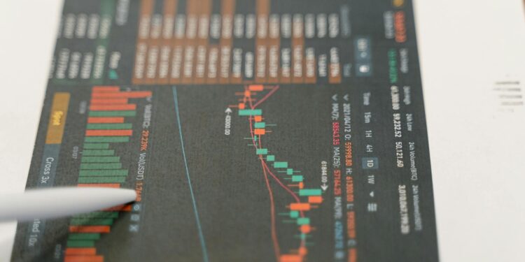 A person analyzing Bitcoin charts on a laptop with graphs and digital currency symbols displayed.